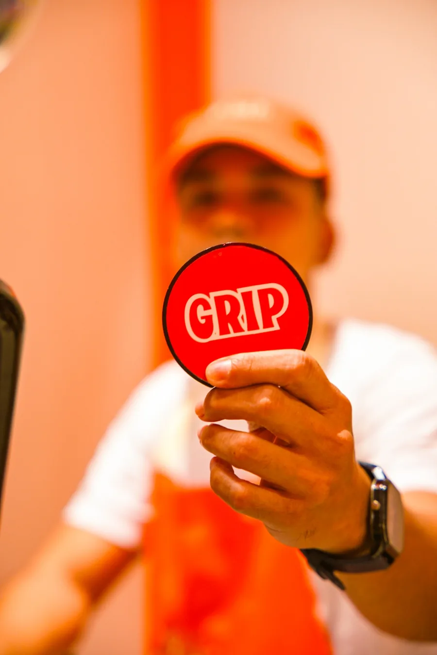 A GRIP team member holding up a round GRIP badge