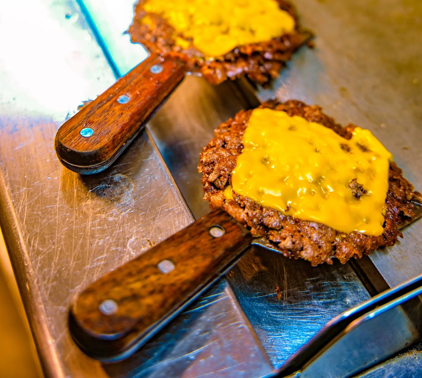 Two smashed beef patties with melted cheese on the GRIP griddle