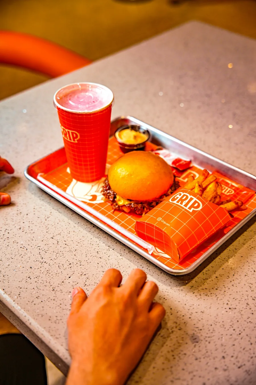 A GRIP smash burger meal on a branded tray with fries and a milkshake